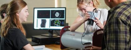 A group of physics students work together in a lab