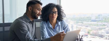 Man and woman working together on a laptop.