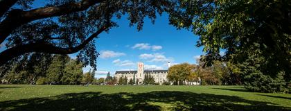 Johnston Hall in the distance, framed by trees in the foreground