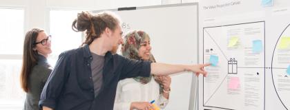 three people looking at business strategy board