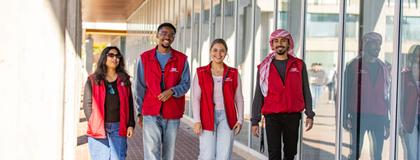 Four Residence Life Staff member walking outside engineering building on campus