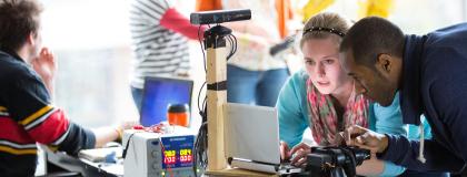 three people working with computers and robotics