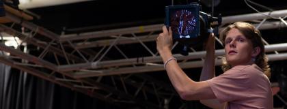 person adjusting stage spotlight