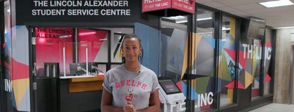 Student standing in front of doors to the Lincoln Alexander Student Service Centre