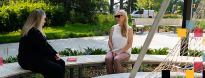 Two people sitting by the fire pit in Lang Plaza.