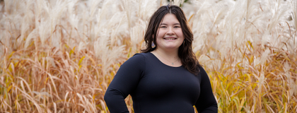 a student standing in a field, wearing black
