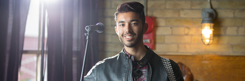 man smiling infront of microphone